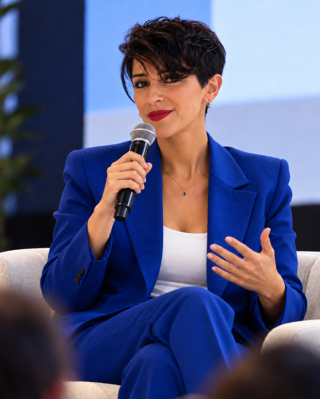Ezgi Turan speaking on a panel in a blue suit